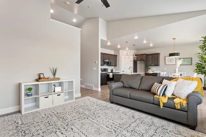 Living room featuring ceiling fan, vaulted ceiling, light wood finished floors, and recessed lighting