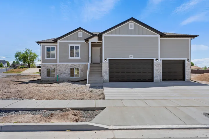 Craftsman-style home featuring concrete driveway, stone siding, board and batten siding, and an attached garage