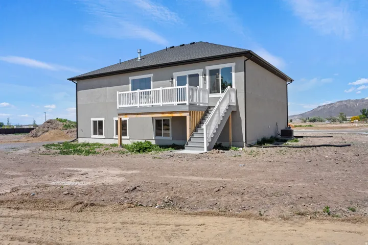 Back of house with a deck with mountain view and stucco siding