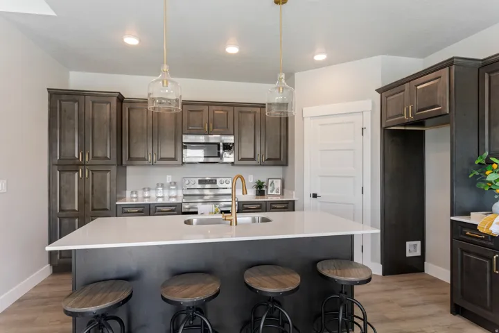 Kitchen featuring dark wood finish cabinets, a kitchen bar, and stainless steel appliances