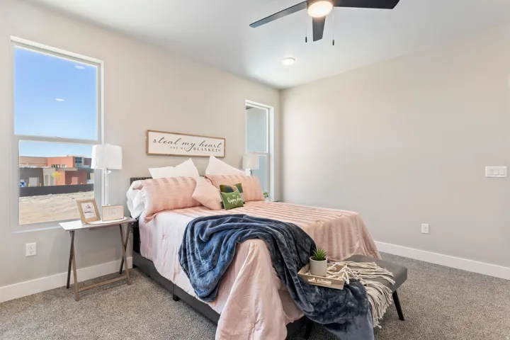Carpeted bedroom featuring baseboards and a ceiling fan