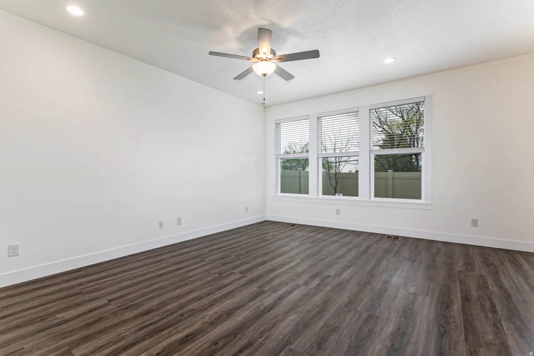 Unfurnished room with dark wood-style floors, a ceiling fan, and recessed lighting