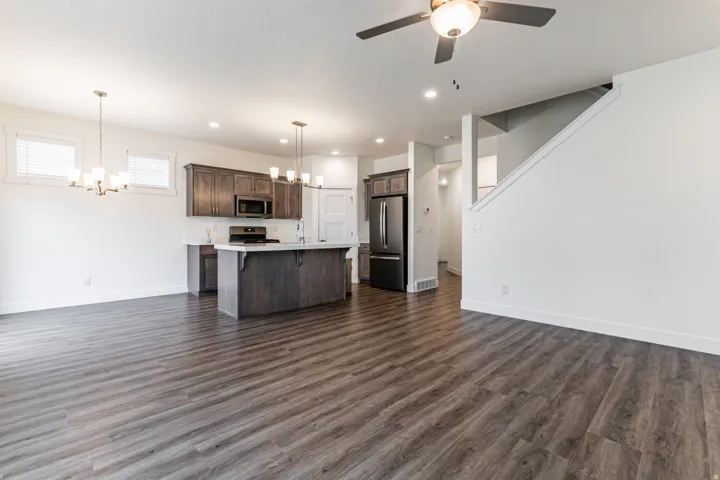 Kitchen featuring suspended lighting, open floor plan, light countertops, and stainless steel appliances