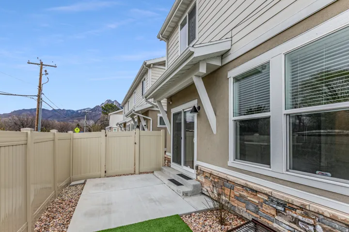Fenced backyard with a mountain view, a gate, entry steps, and a patio