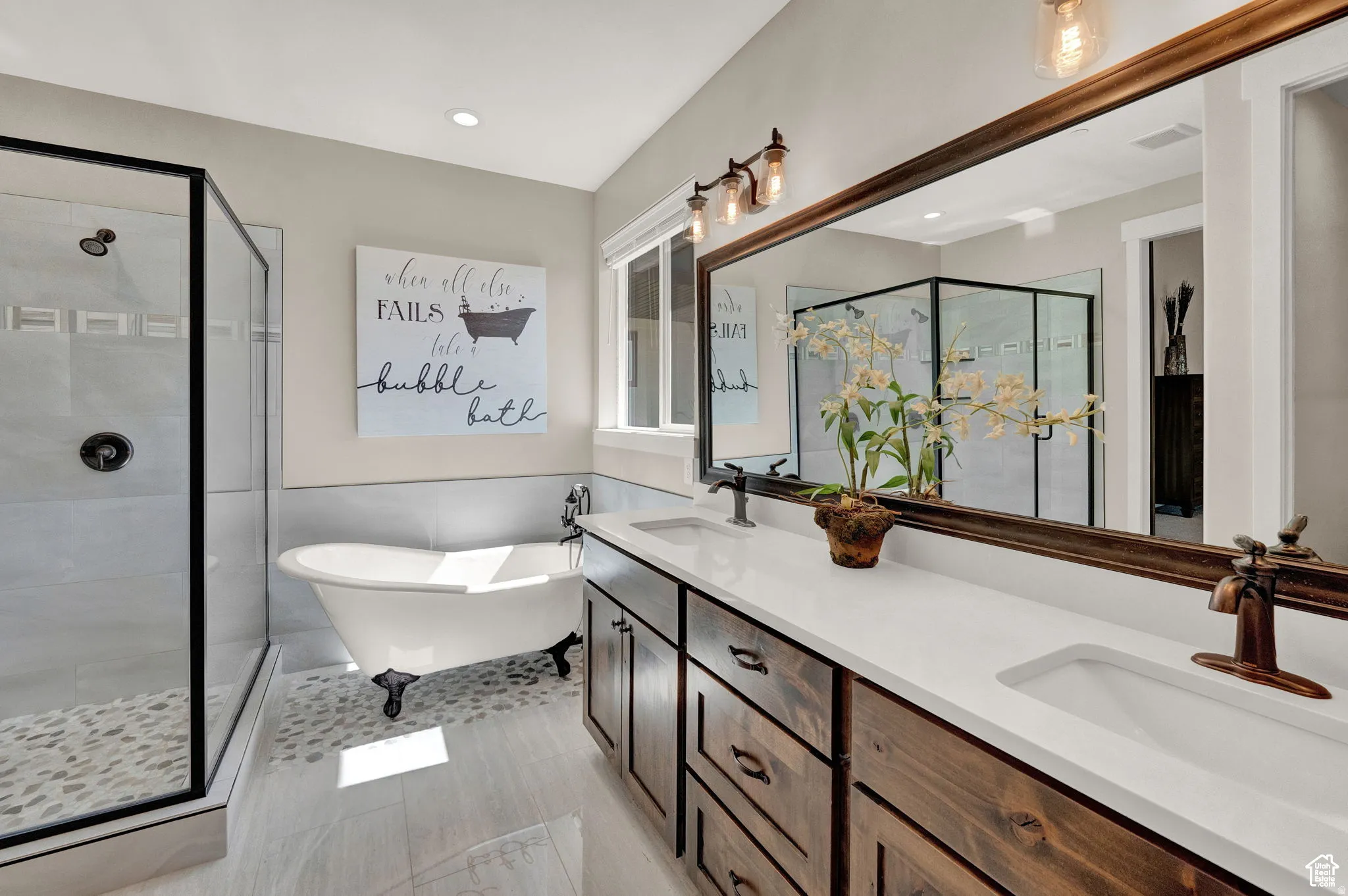 Full bath featuring a shower stall, a wainscoted wall, double vanity, and a freestanding tub