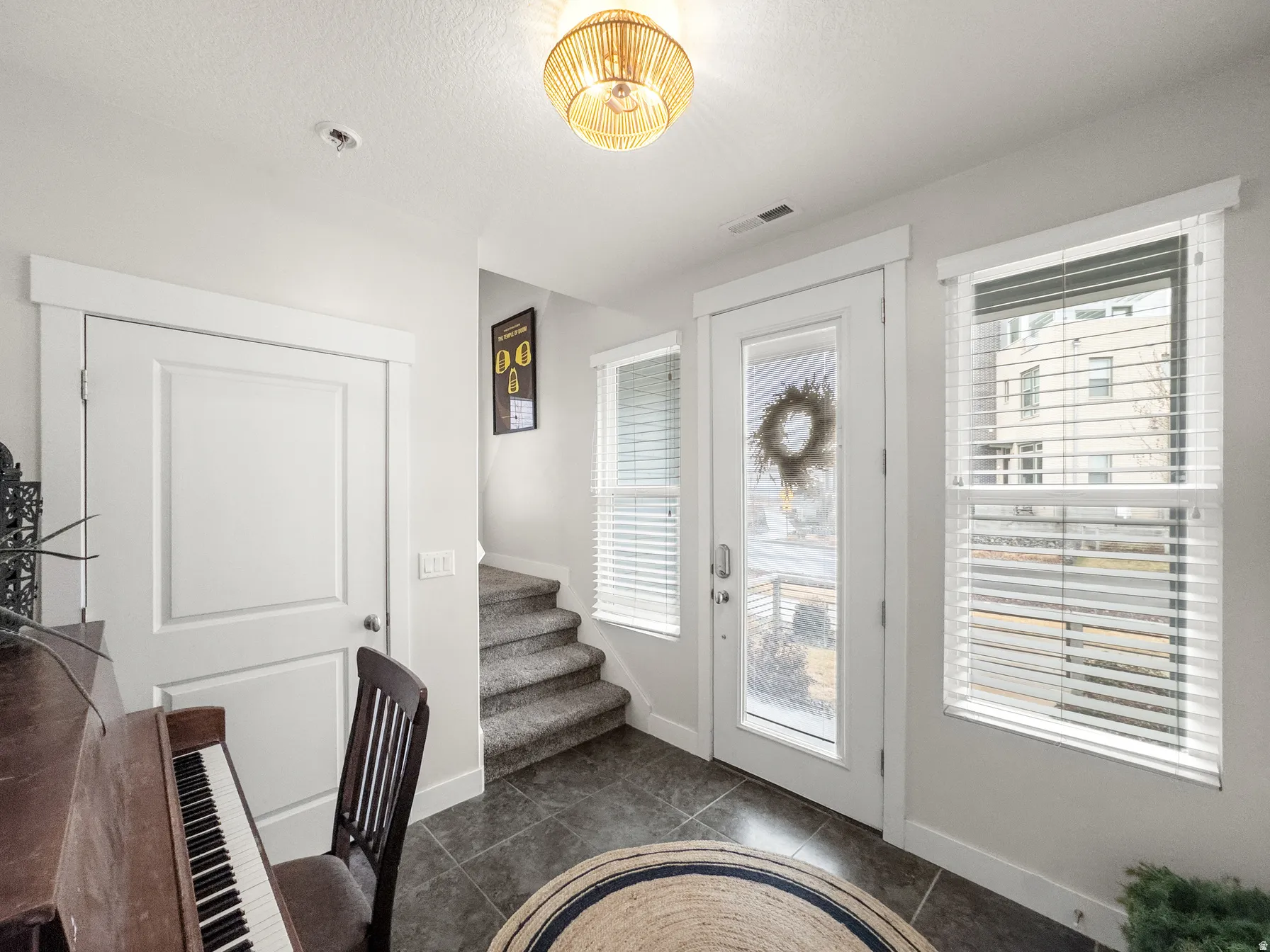 Entrance foyer featuring stairway and dark tile patterned flooring