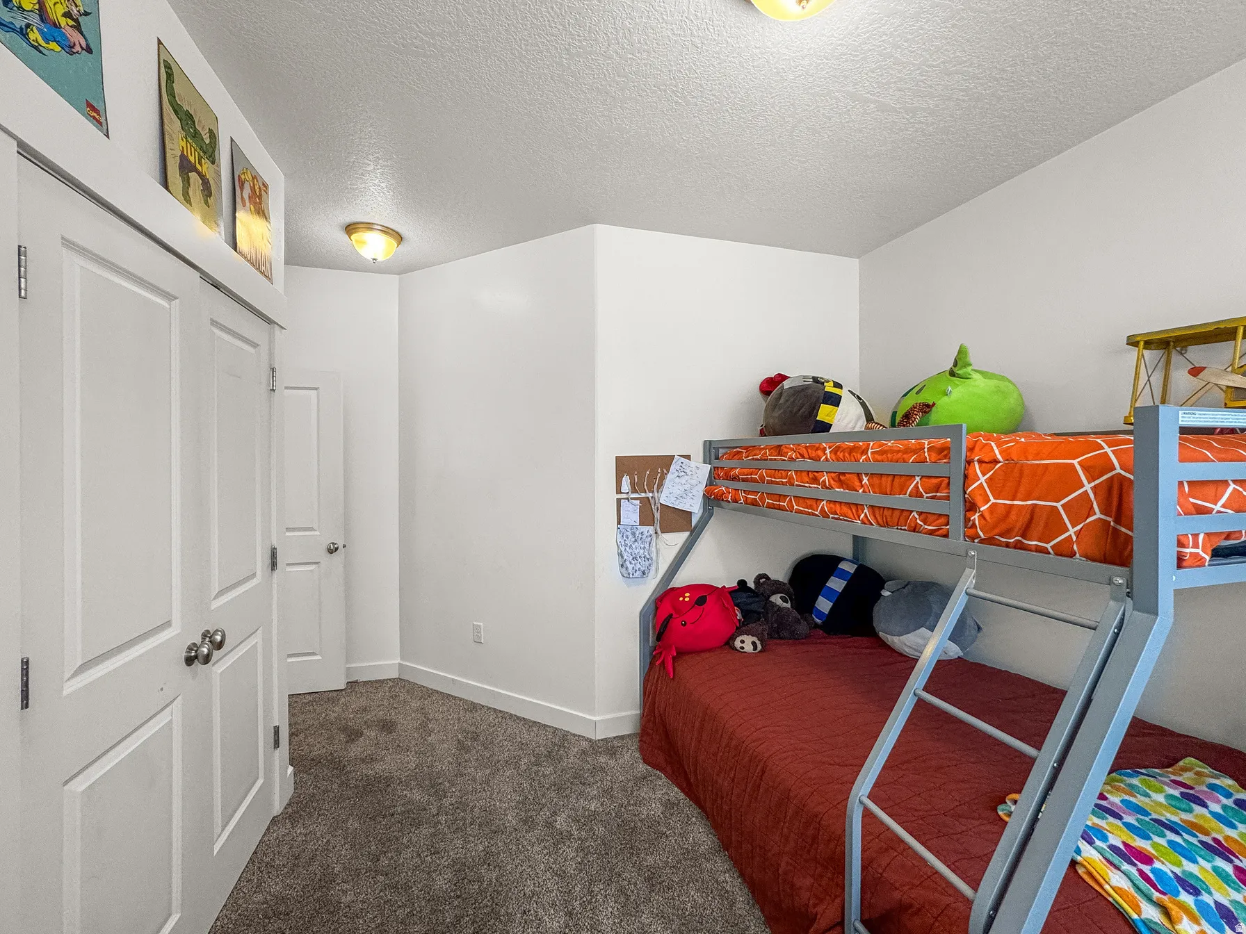 Bedroom featuring dark colored carpet, a textured ceiling, and a closet