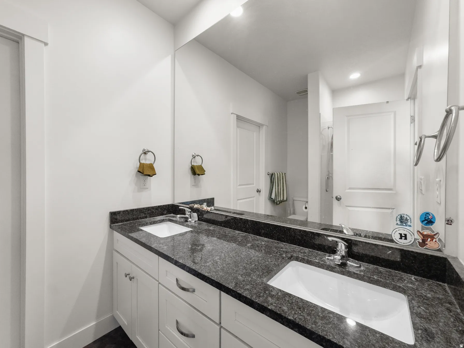 Full bath with double vanity, recessed lighting, and a shower