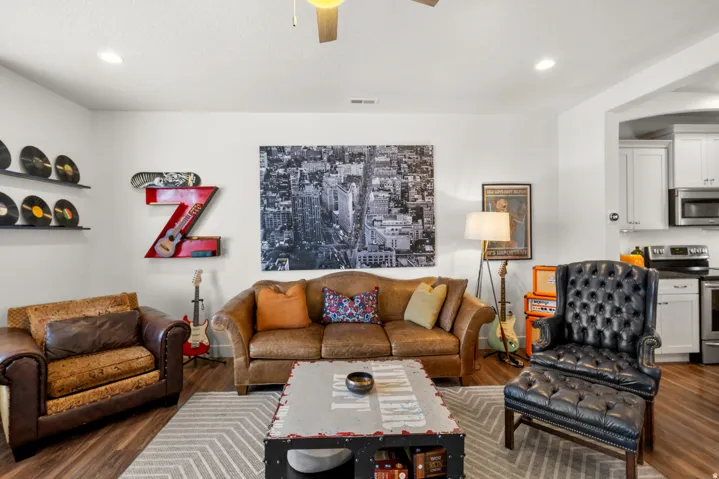 Living area featuring ceiling fan, dark wood-type flooring, and recessed lighting