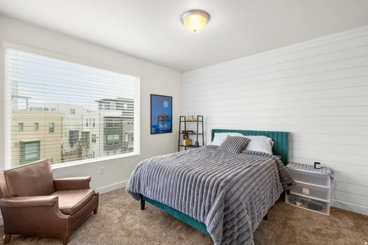 Bedroom featuring carpet and wooden walls