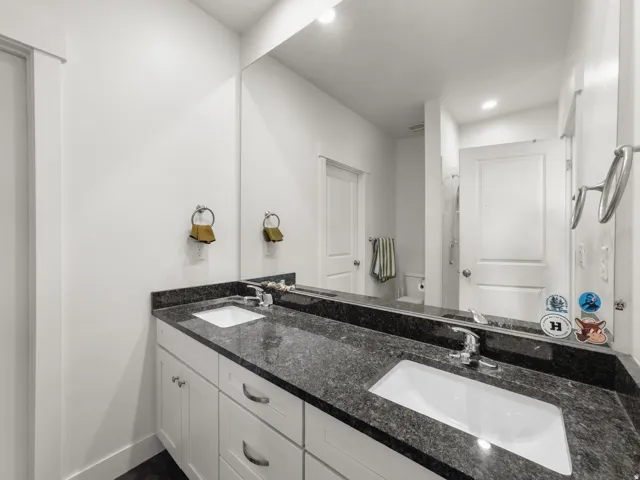 Full bath with double vanity, recessed lighting, and a shower