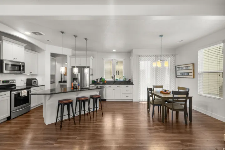Kitchen featuring stainless steel appliances, a kitchen breakfast bar, white cabinets, and a center island