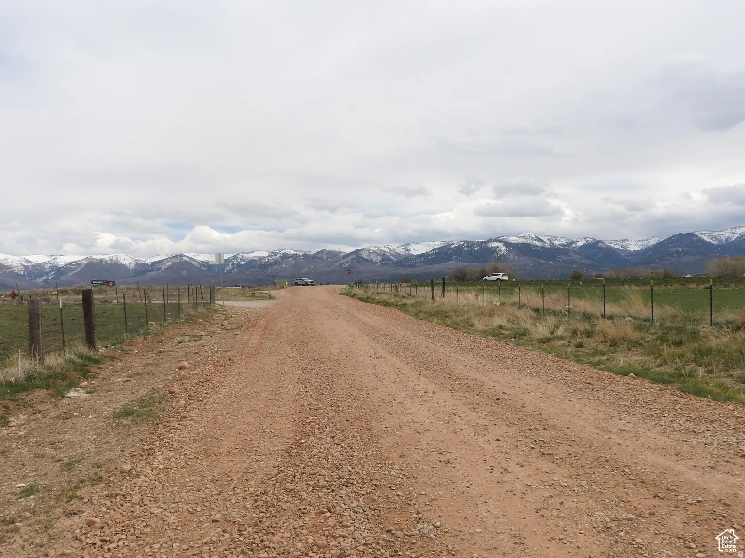 View of dirt / gravel road with a rural view and a mountain view