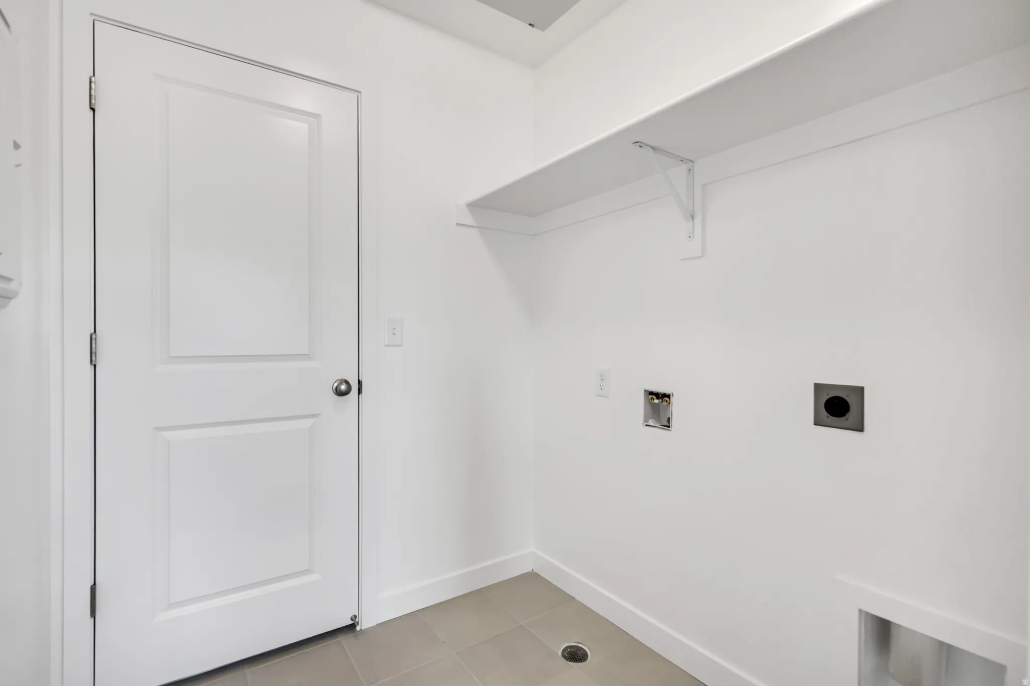 Laundry room with light tile patterned floors, washer hookup, and electric dryer hookup