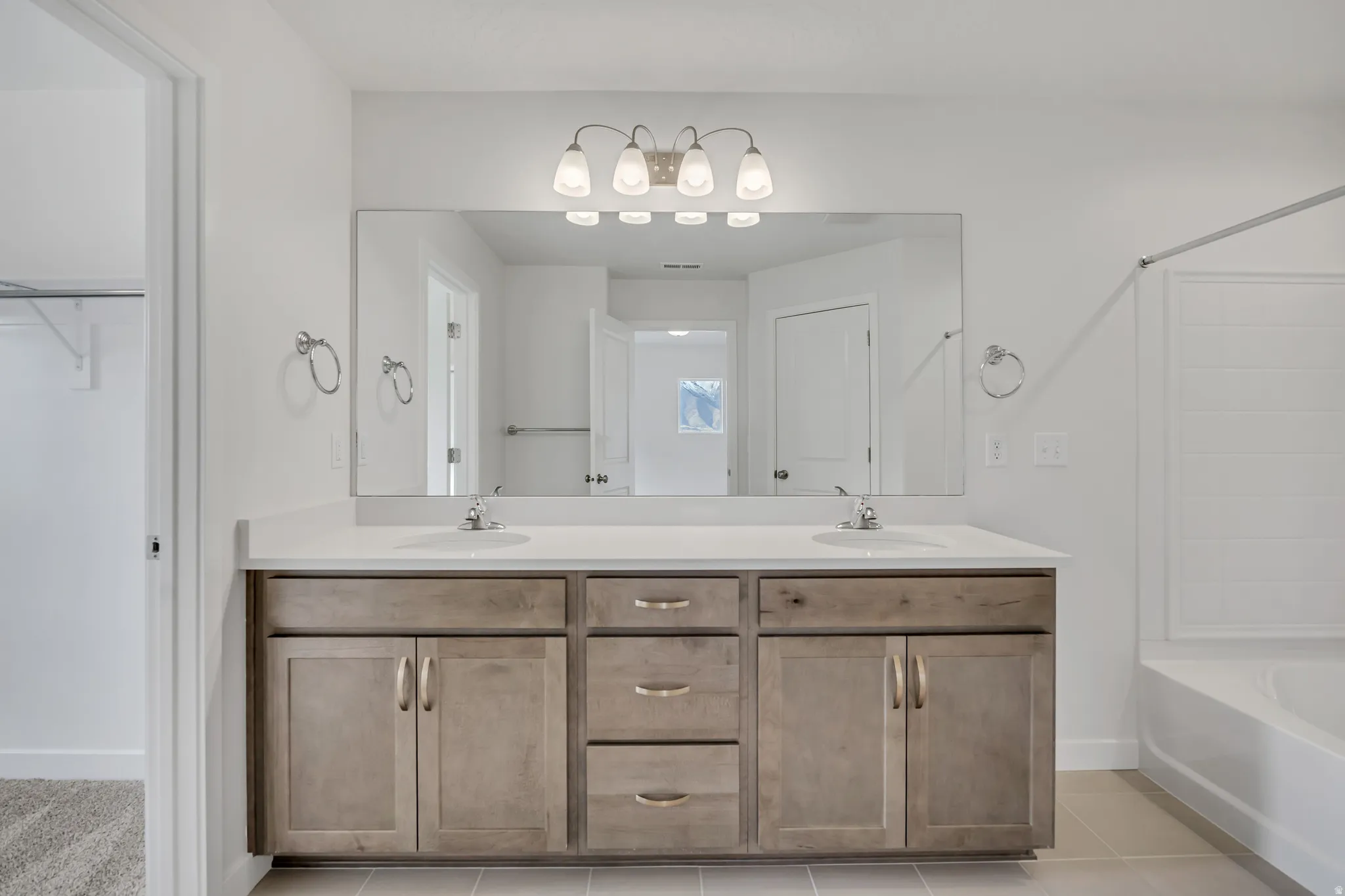Full bathroom featuring double vanity, bathing tub / shower combination, a spacious closet, and light tile patterned floors