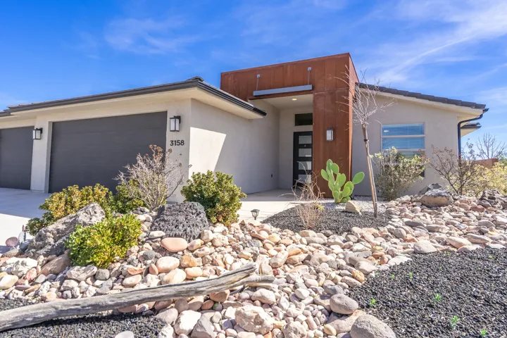 Contemporary house featuring an attached garage, stucco siding, and concrete driveway