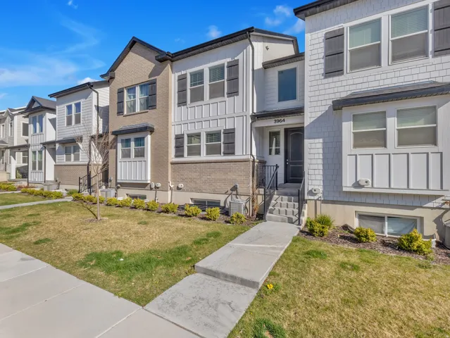 Traditional home with a front yard, brick siding, a residential view, and entry steps