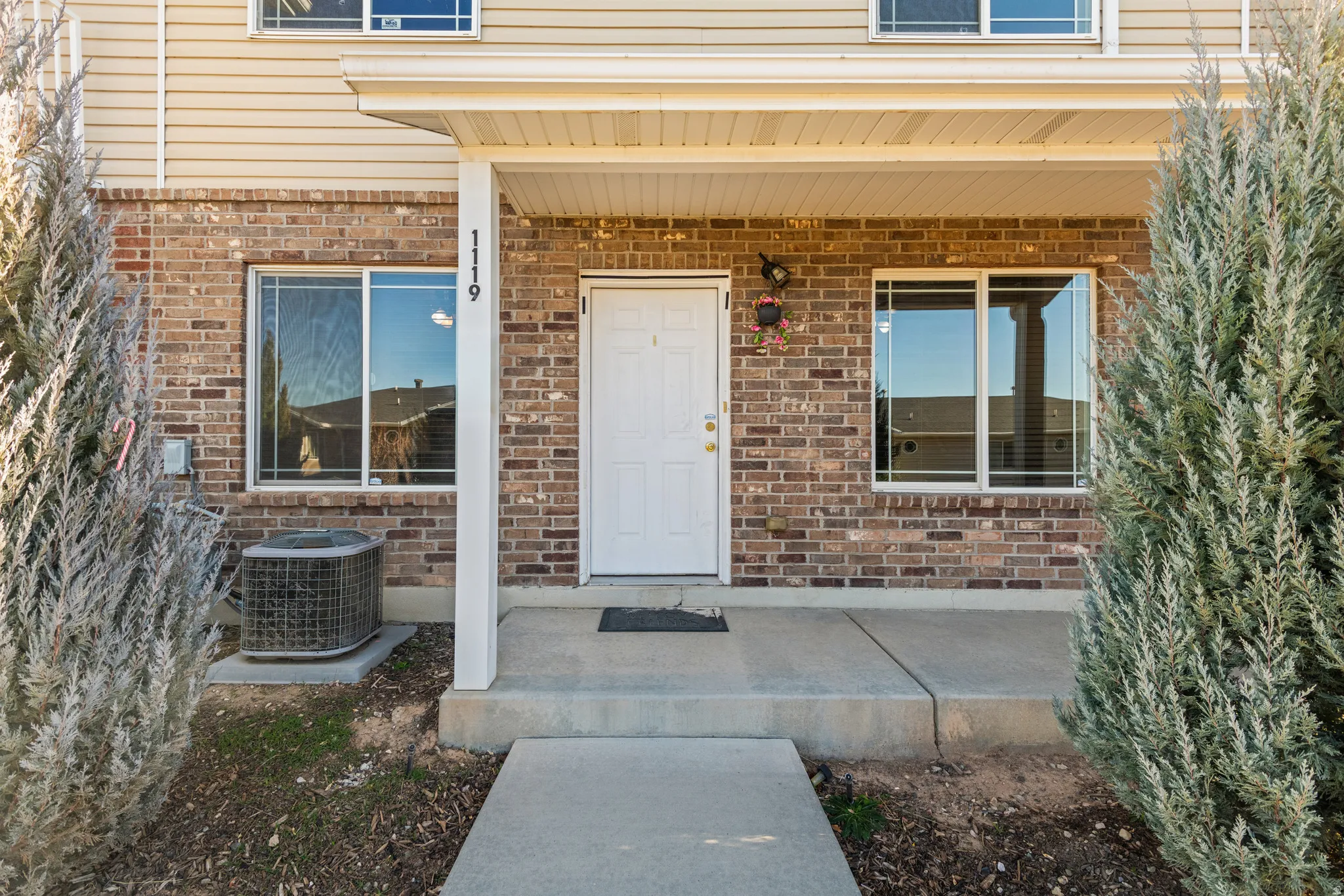 View of exterior entry featuring covered porch and brick siding