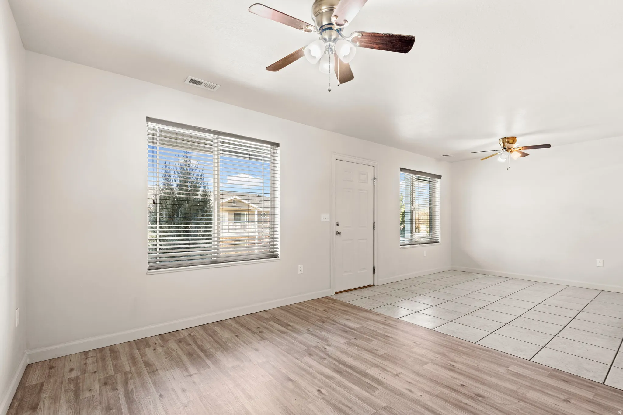 Entrance foyer with a ceiling fan and light wood finished floors