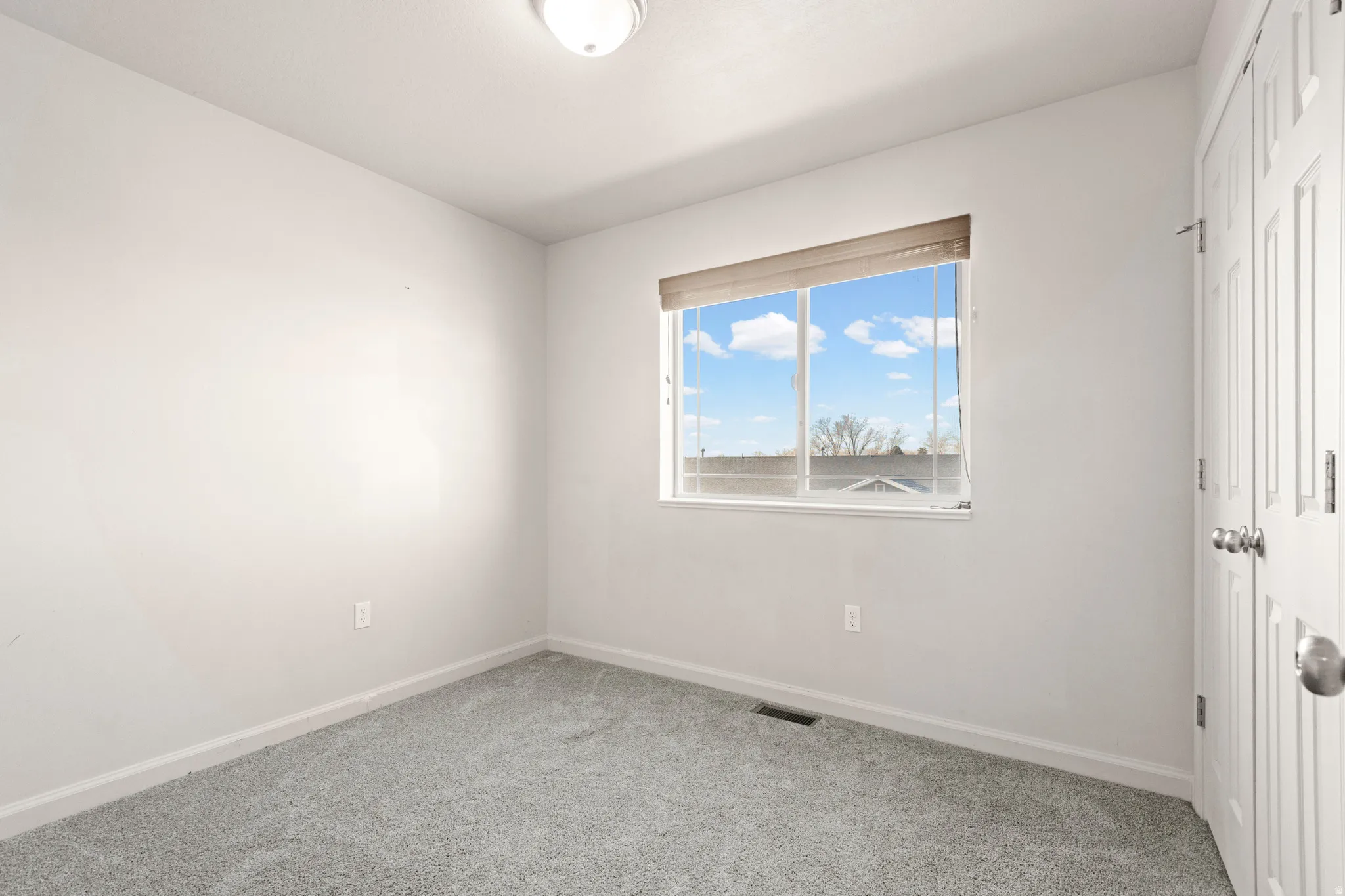 Unfurnished bedroom featuring a closet and light colored carpet