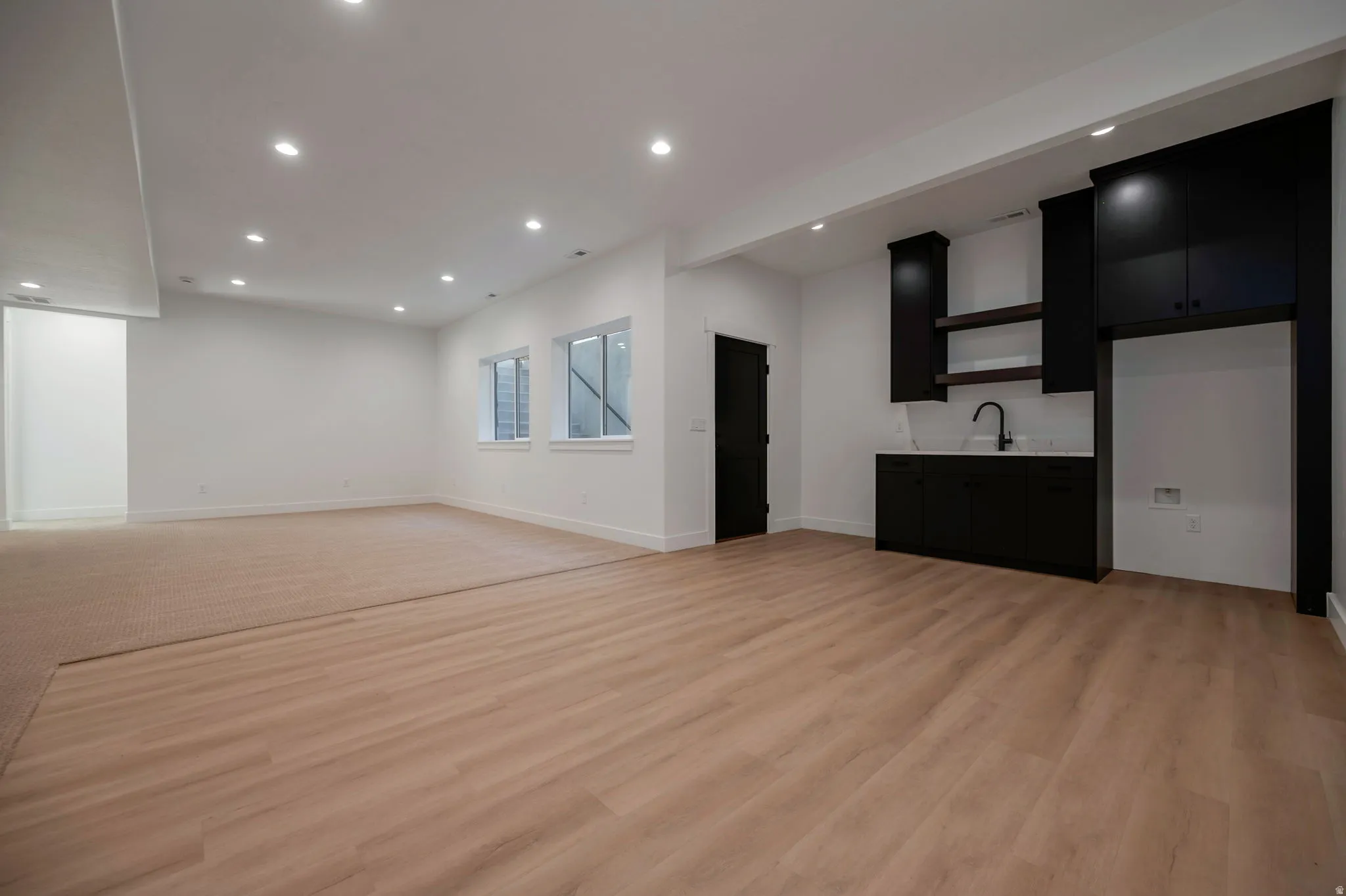 Bar with dark cabinets, recessed lighting, light countertops, light wood-style flooring, and open shelves
