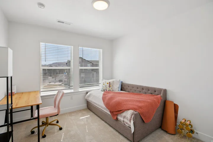 Bedroom featuring light colored carpet and baseboards