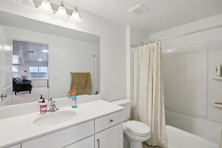 Bathroom featuring vanity and shower / bath combo with shower curtain