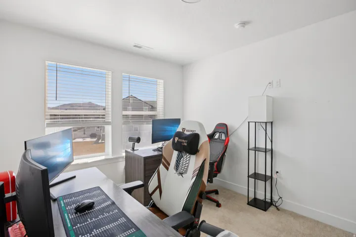 Office area featuring light colored carpet and baseboards
