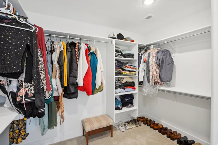 Walk in closet featuring light colored carpet