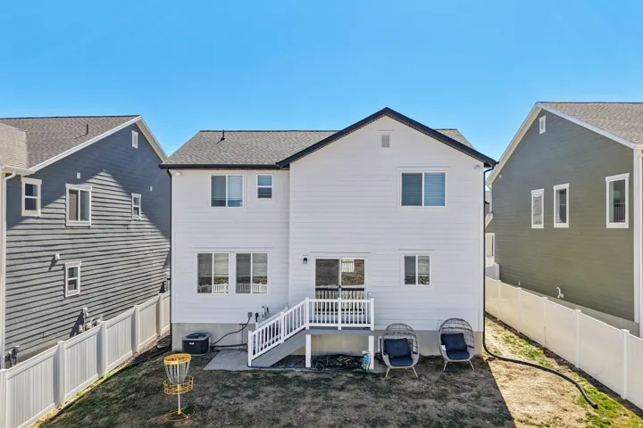 Back of house with a fenced backyard, a patio, and a deck