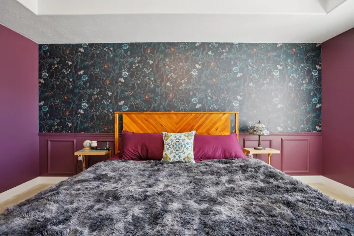 Carpeted bedroom featuring a wainscoted wall, wallpapered walls, and a decorative wall