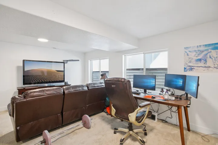 Office space with light carpet, healthy amount of natural light, and a textured ceiling