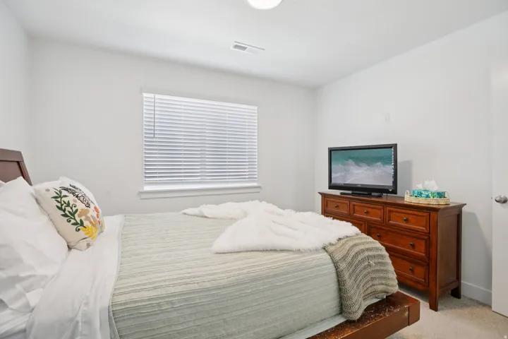 Bedroom featuring light carpet and baseboards