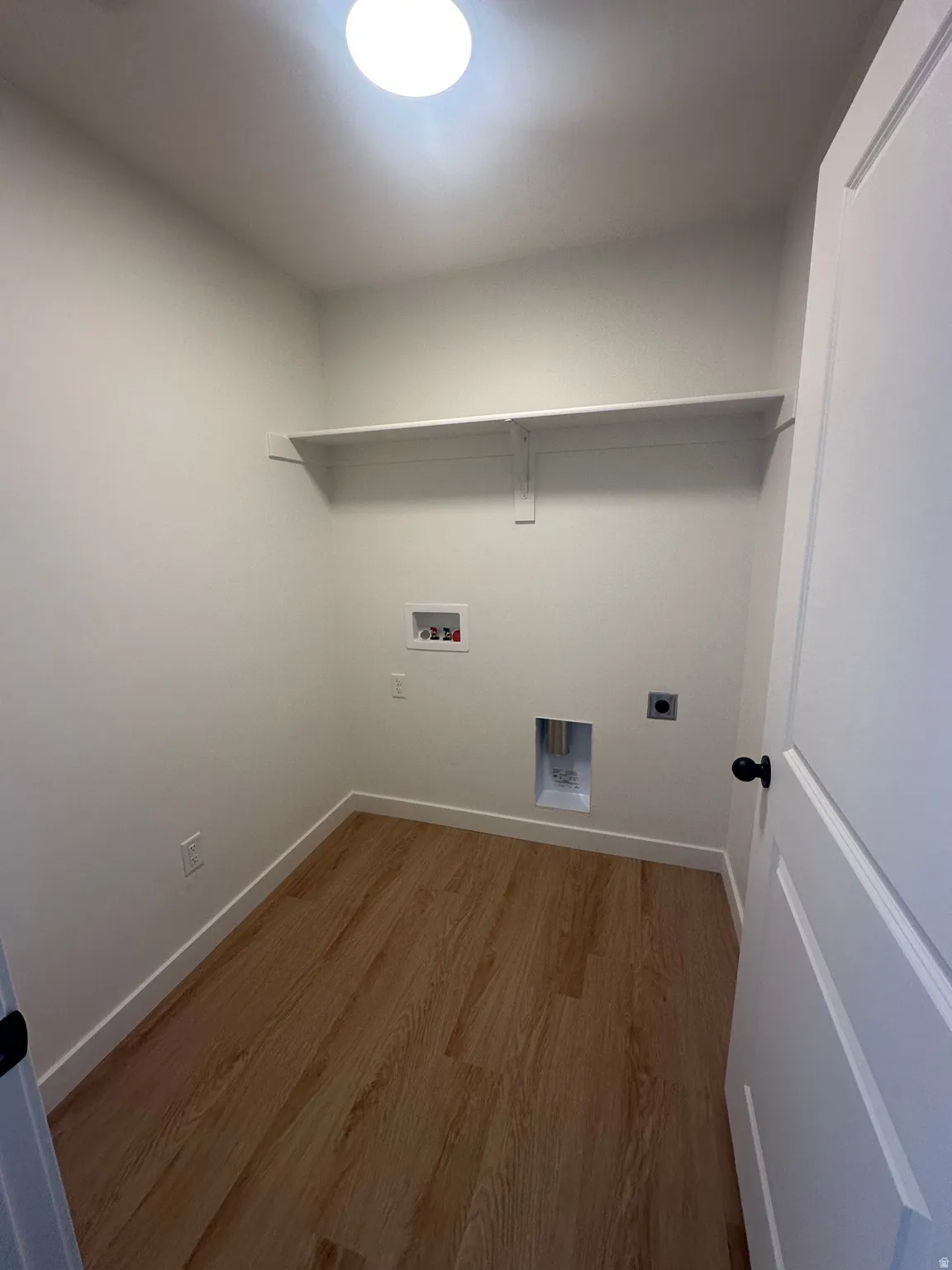Laundry room with wood finished floors, hookup for an electric dryer, and hookup for a washing machine