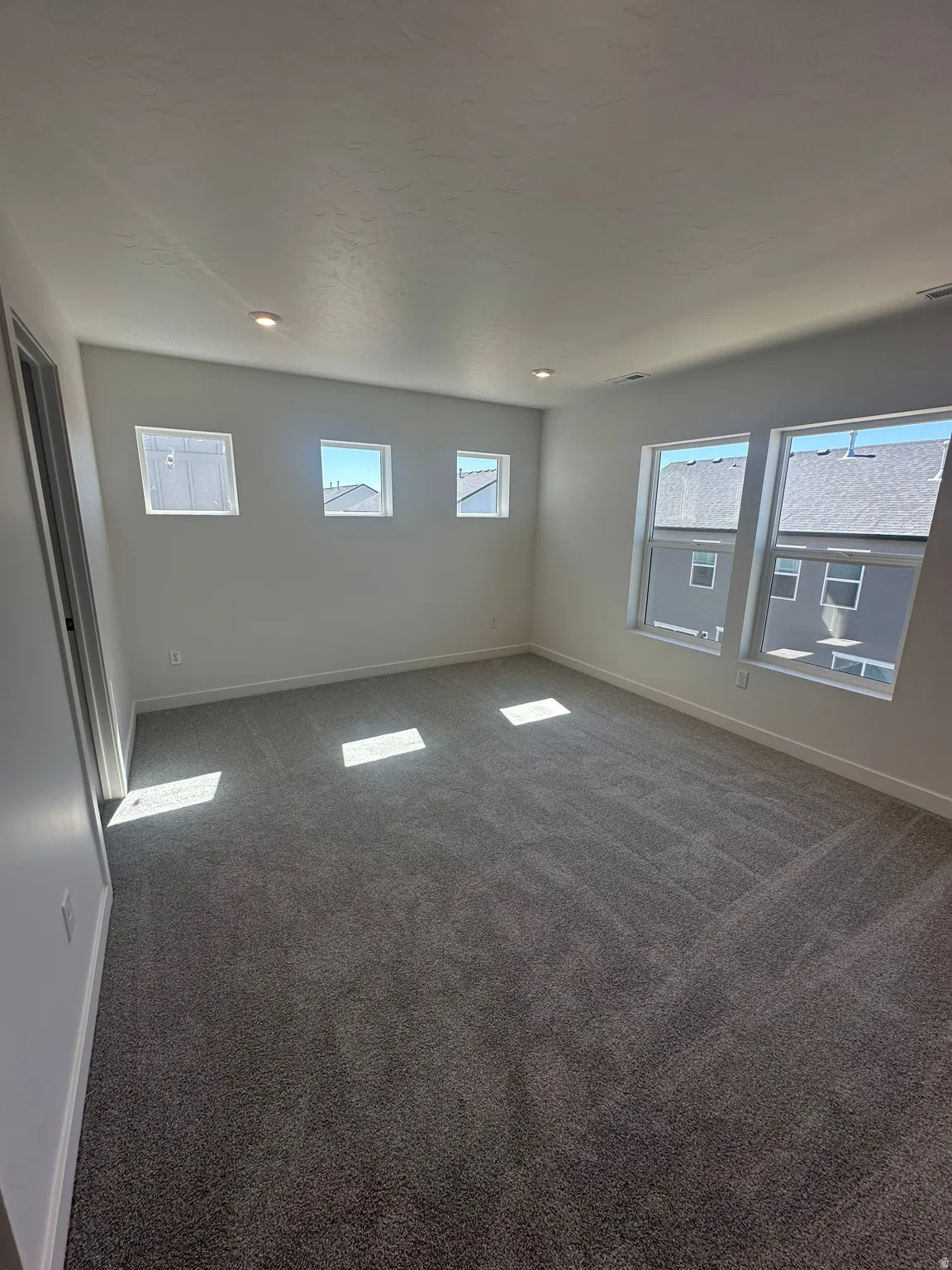 Spare room with baseboards and dark colored carpet