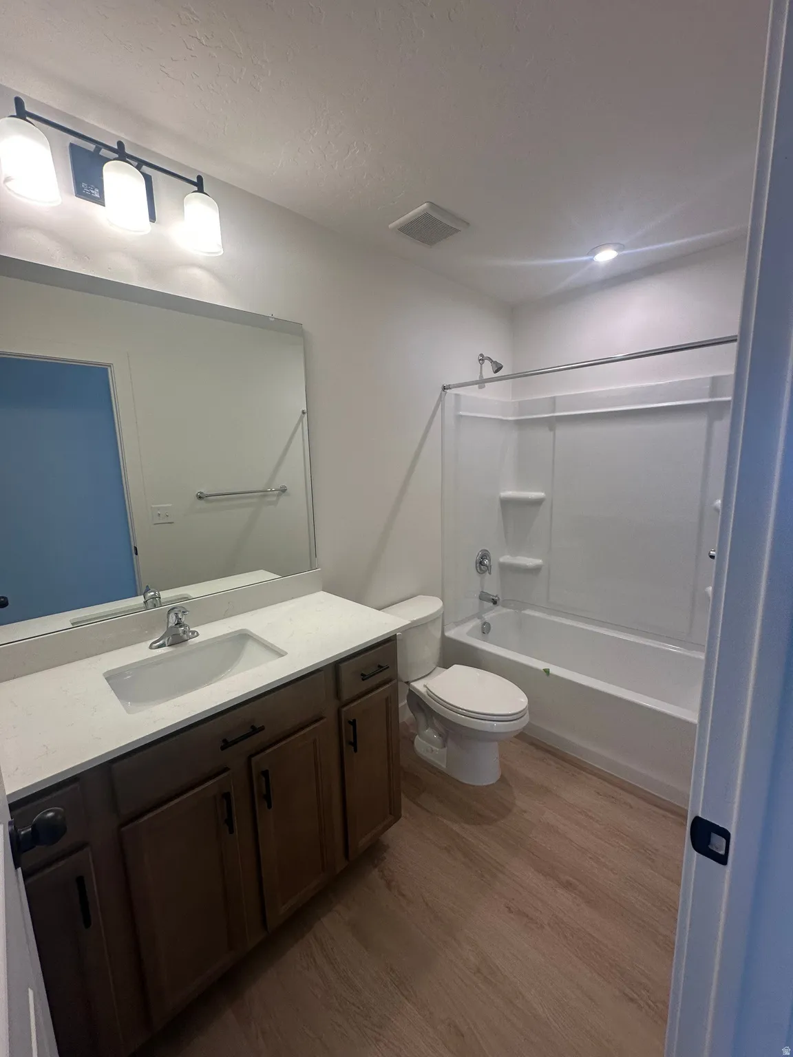 Bathroom with vanity,  shower combination, and dark wood finished floors