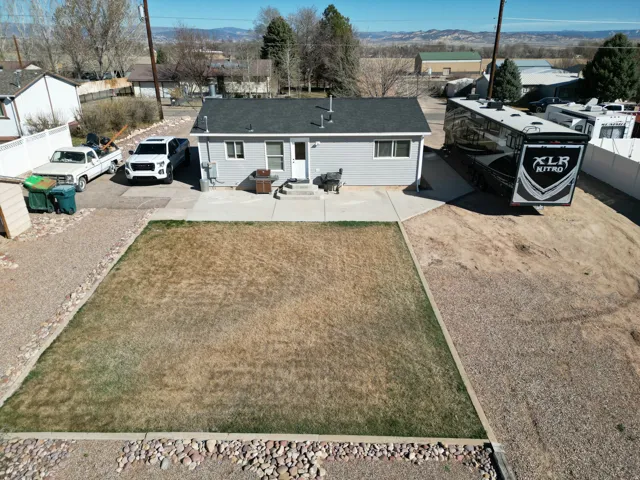 Rear view of house featuring driveway, a mountain view, a residential view, and a patio