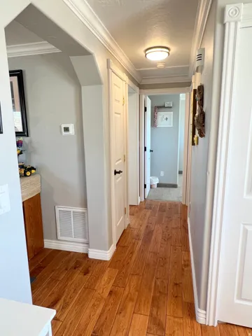 Hallway featuring crown molding and light wood-style flooring