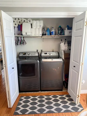 Laundry area with light wood finished floors and washer and dryer