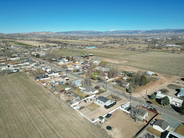 Aerial view of property and surrounding area with rural landscape, mountains, and nearby suburban area-looking north west