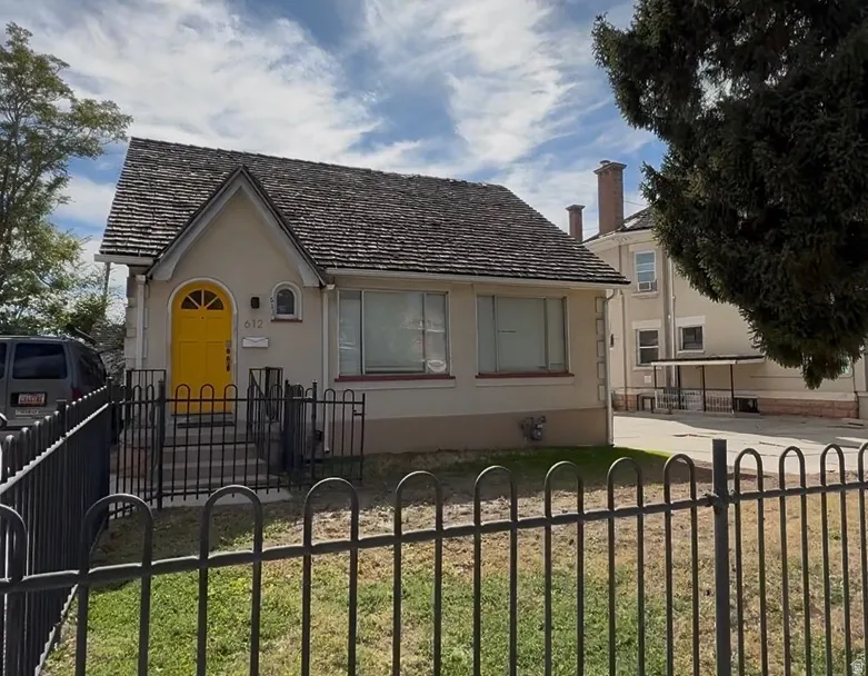 View of front facade with a fenced front yard and stucco siding