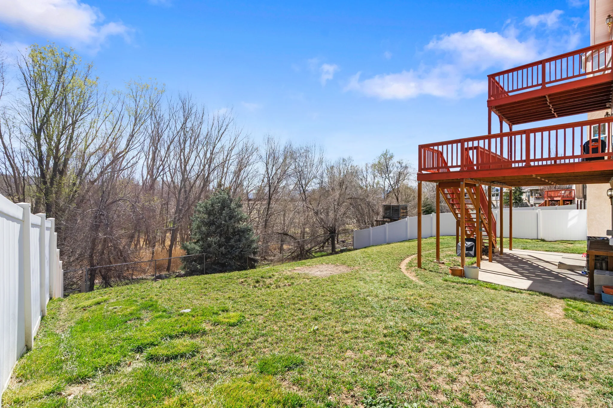 Fenced backyard featuring a patio area and a wooden deck