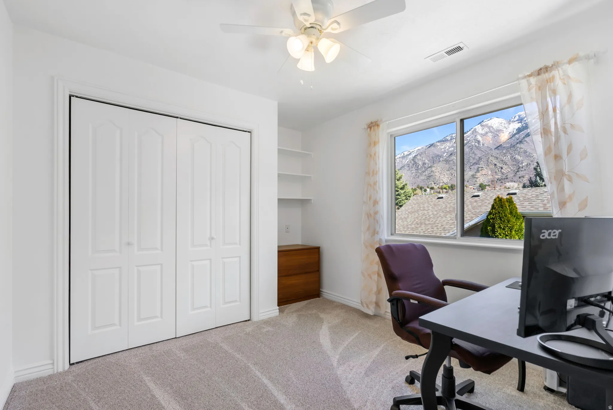 Office area with light carpet and ceiling fan