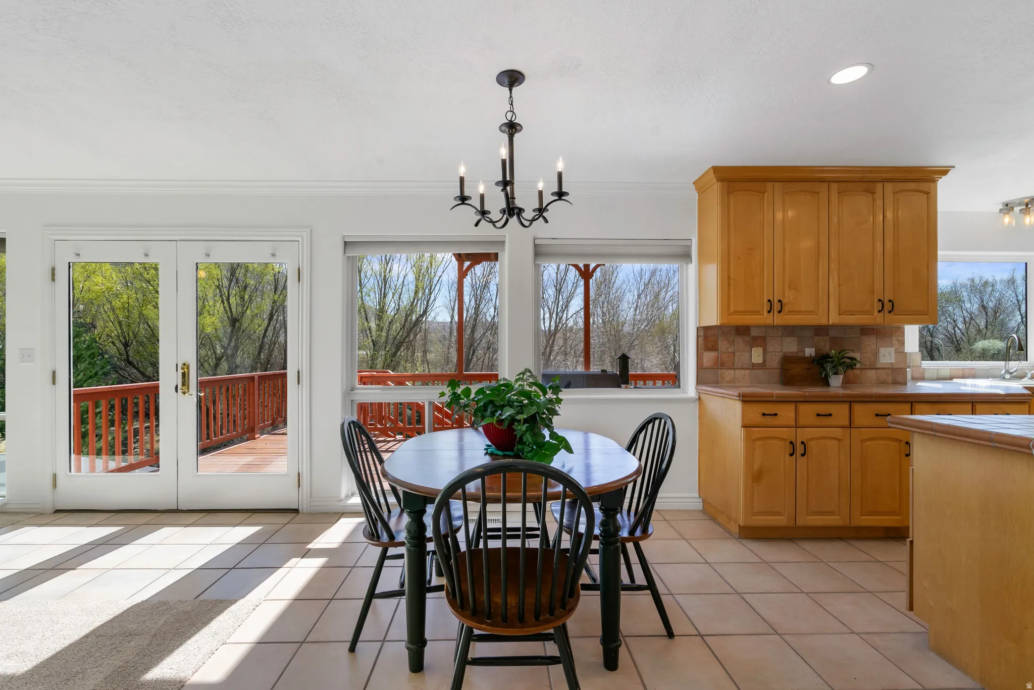 Dining space with french doors, light tile patterned floors, and suspended lighting