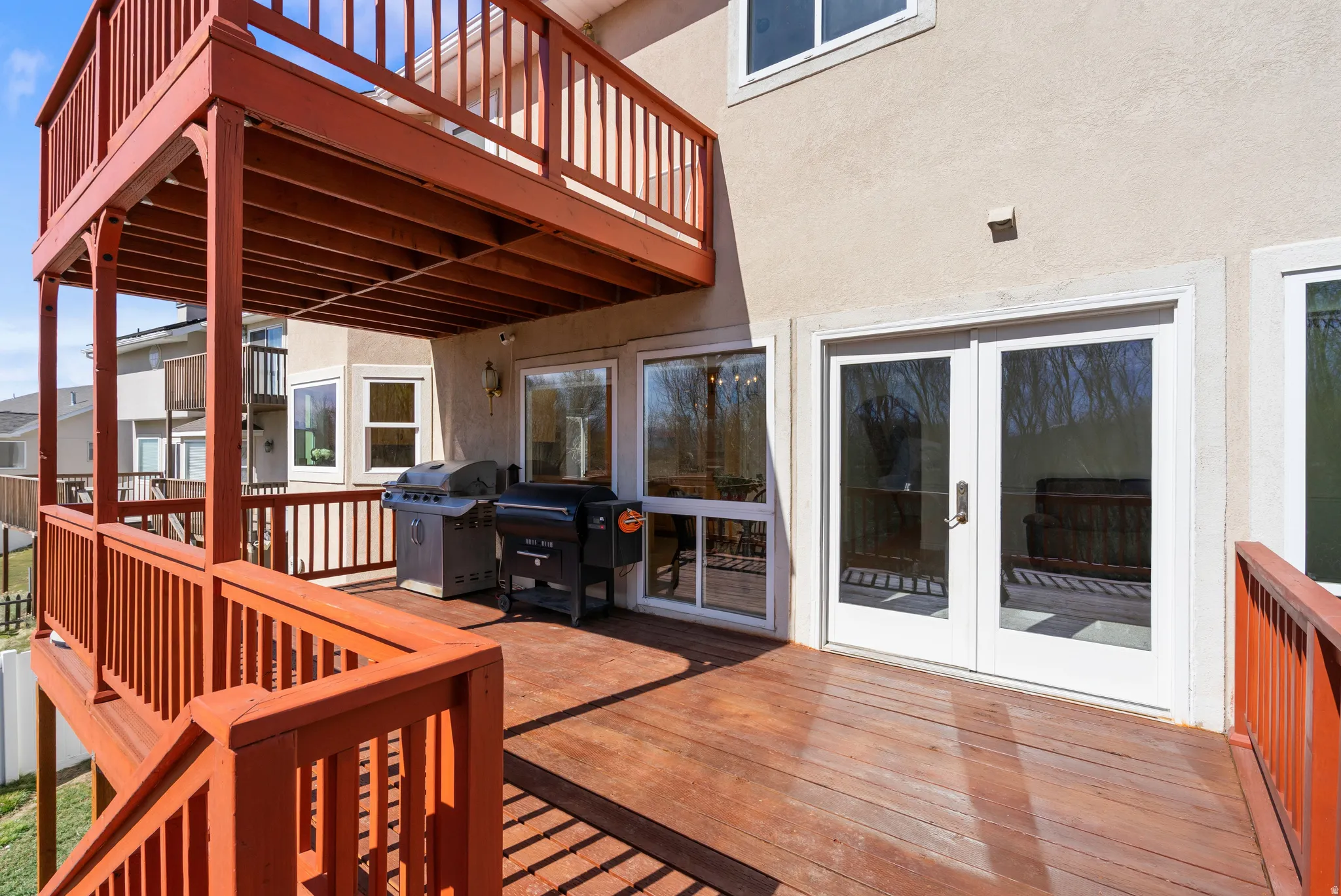 Wooden terrace with area for grilling and french doors