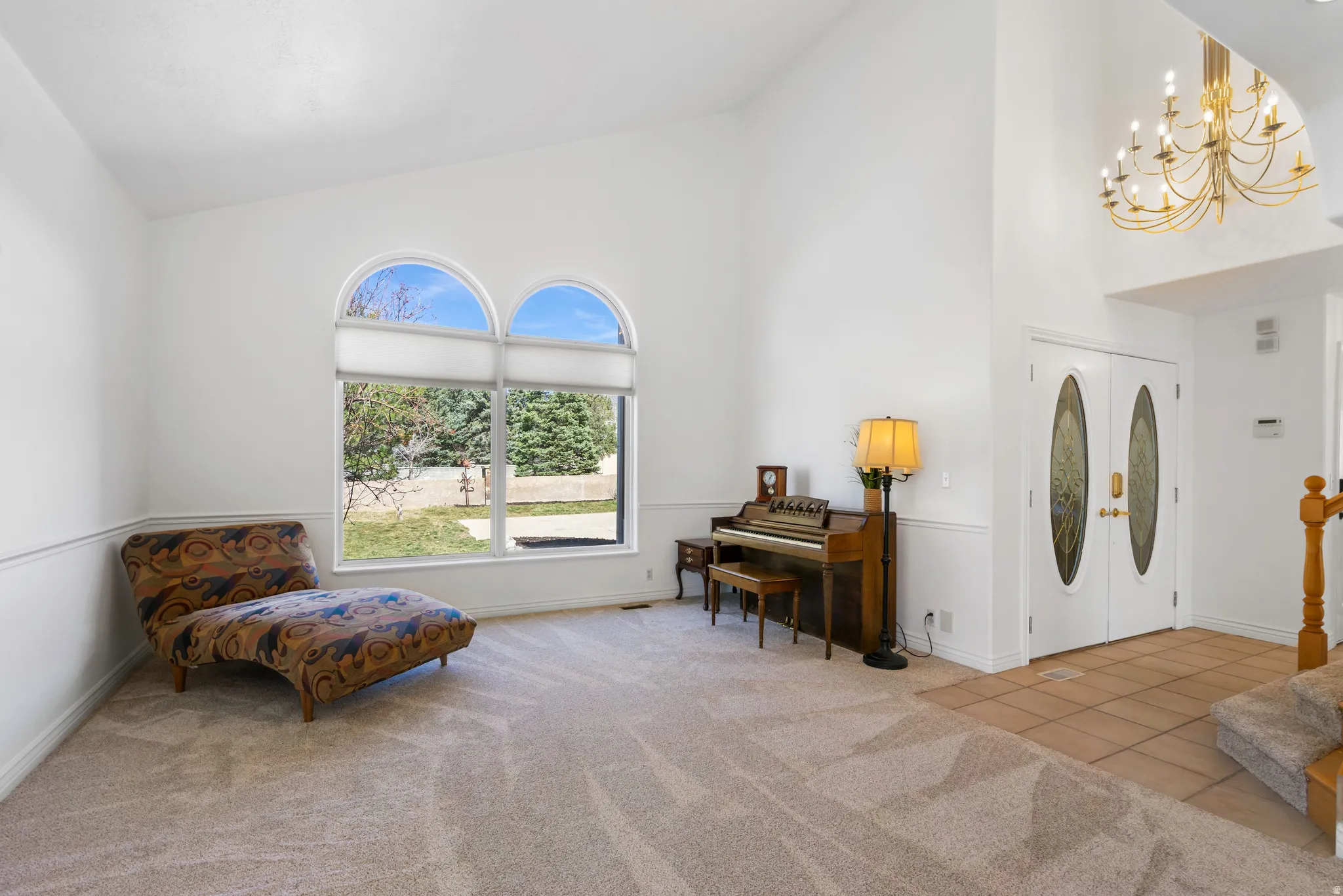 Sitting room featuring lofted ceiling, light colored carpet, and hanging lights