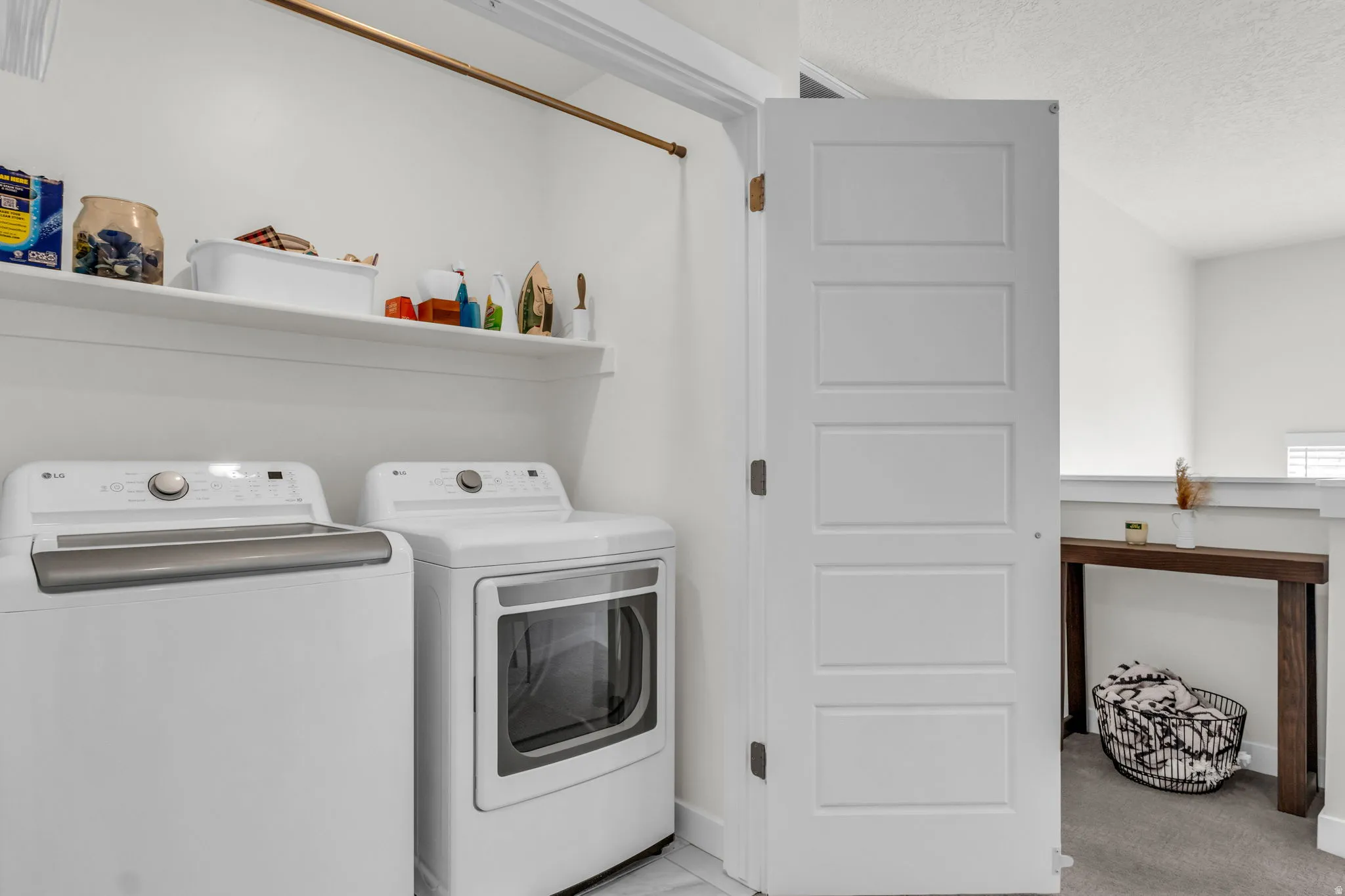 Laundry area with washing machine and clothes dryer and a textured ceiling