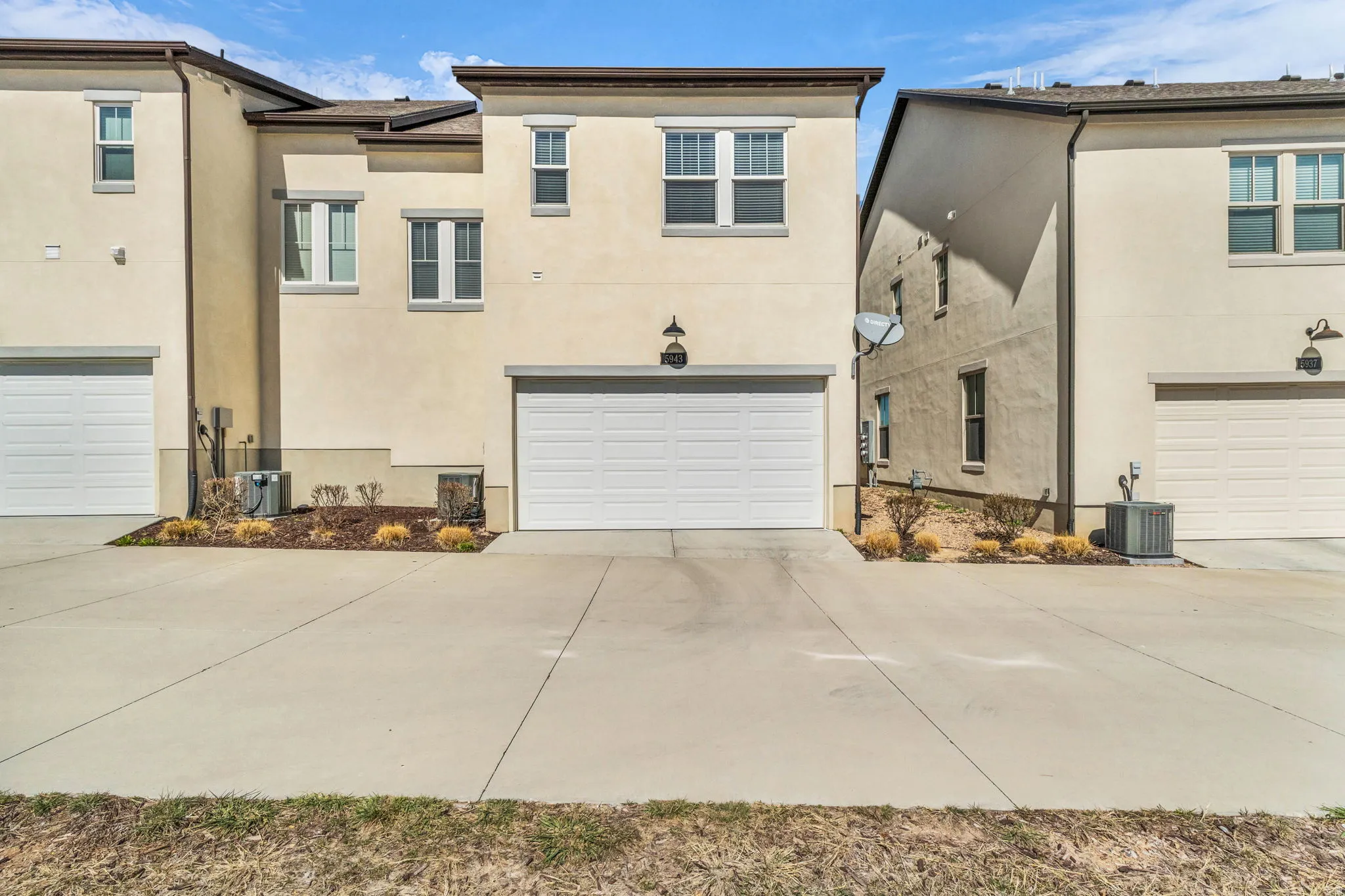 View of front of house featuring stucco siding, driveway, and a garage