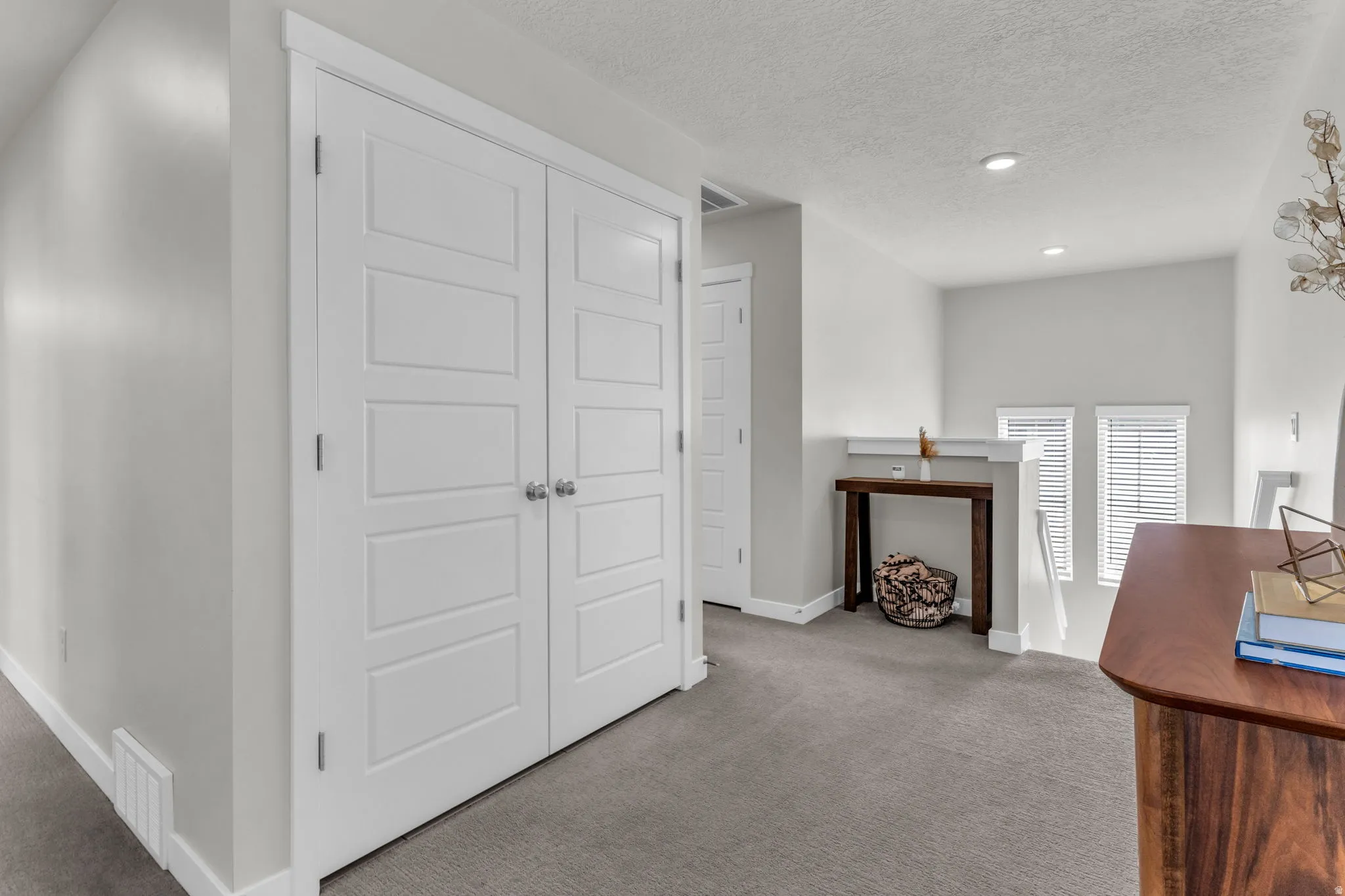 Carpeted office with baseboards and a textured ceiling