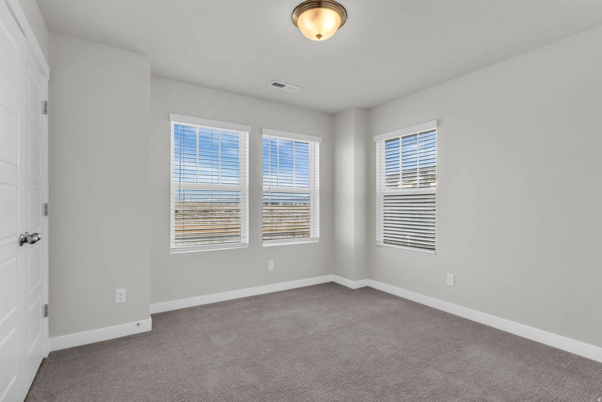 Unfurnished room with baseboards and dark colored carpet